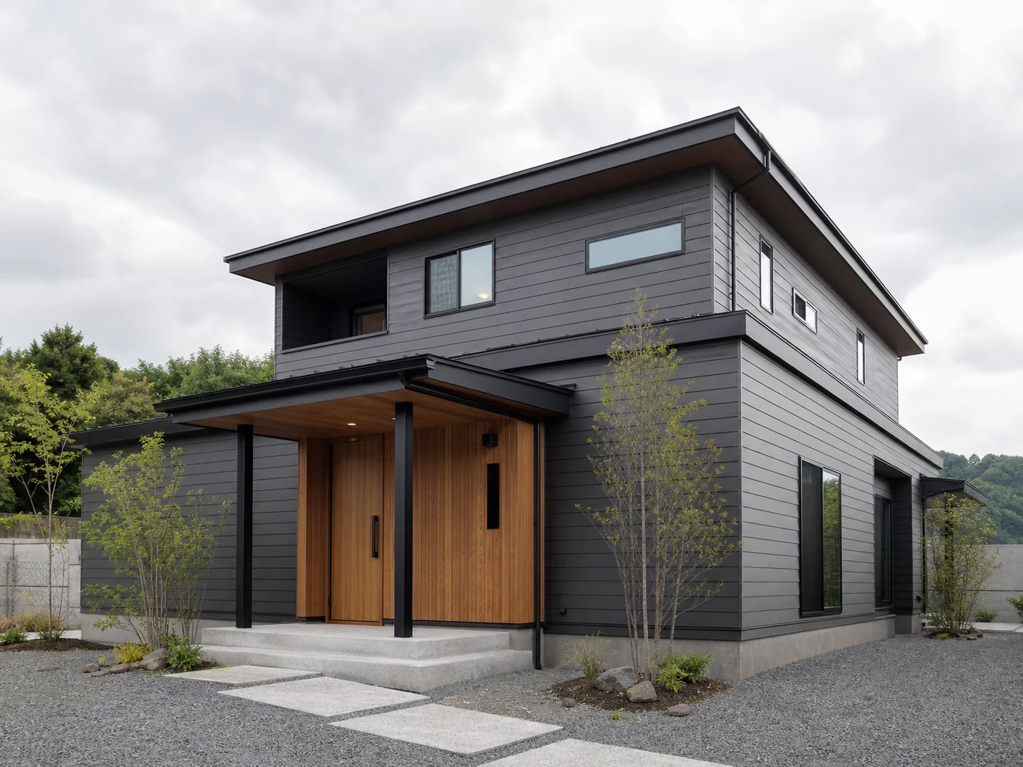 黒い外壁と木の玄関が印象的な新築住宅